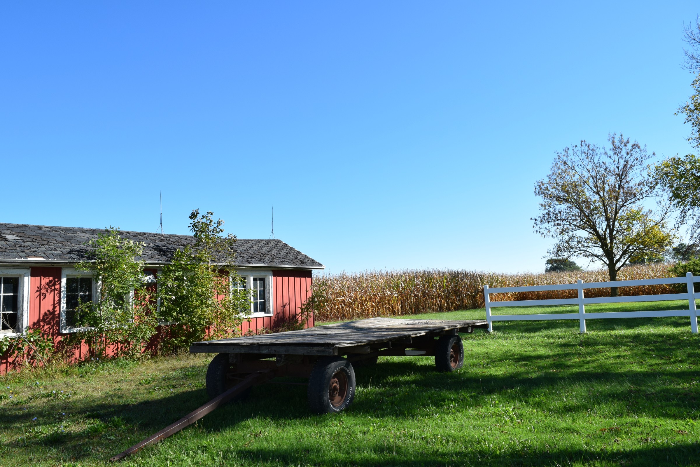 Barn, green grass and trailer